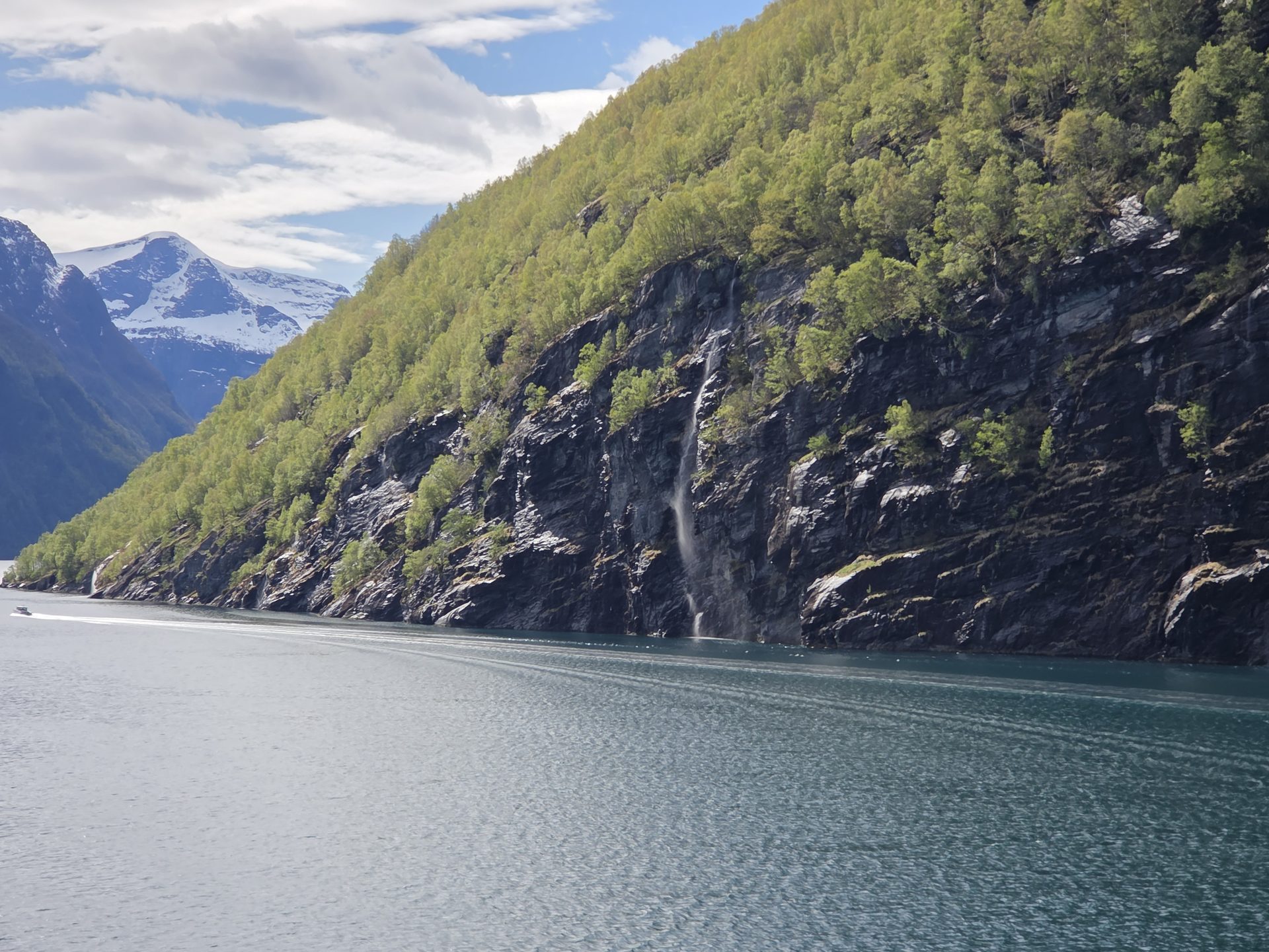 A deep fjord winding between steep mountain walls under a clear sky.