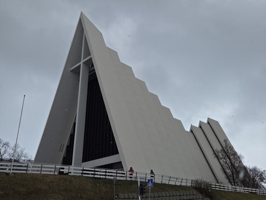 The white triangular Arctic Cathedral in Tromso set against a blue sky.
